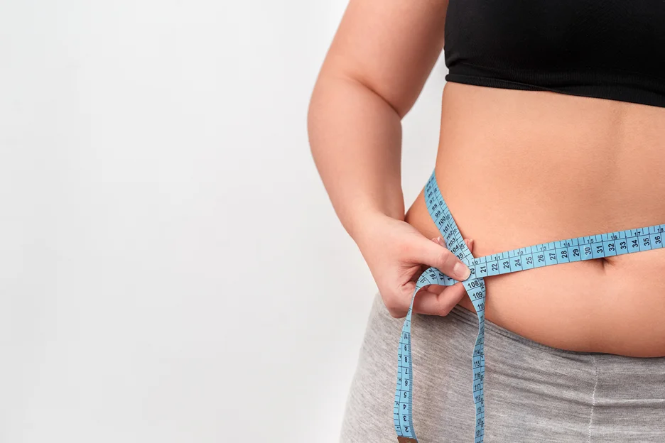 A woman measuring her fatty stomach